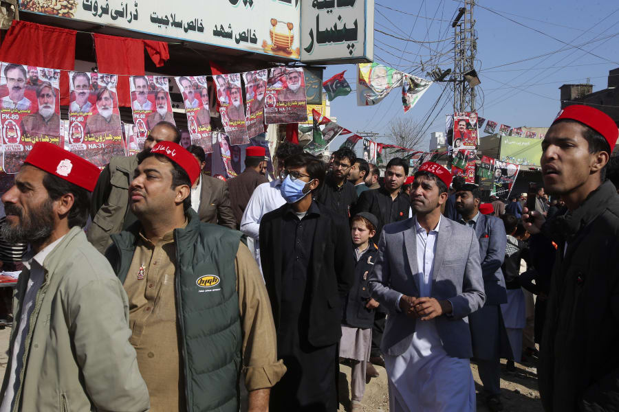 People gather outside a polling station during the country's parliamentary elections in Jamrud, in the Khyber district, Pakistan, Thursday, Feb. 8, 2024. Pakistanis lined braved cold winter weather and the threat of violence to vote for a new parliament Thursday, a day after twin bombings claimed at least 30 lives in the worst election-related violence ahead of the contested elections. (AP Photo/Muhammad Sajjad)