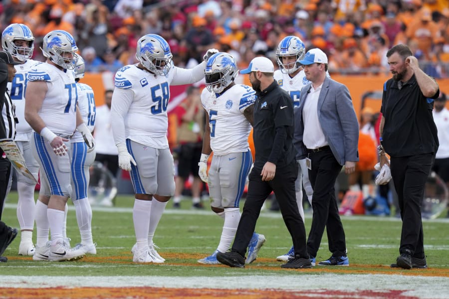 Detroit Lions running back David Montgomery (5) walks off the field after being injured as Penei Sewell (58) taps his helmet during the first half of an NFL football game against the Tampa Bay Buccaneers Sunday, Oct. 15, 2023, in Tampa, Fla.