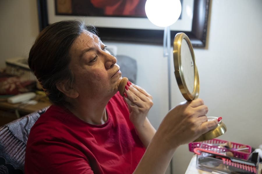 Christina Wood applies makeup and gets ready before going to work in her home in Salem, Ore., Friday, April 21, 2023. Six years ago, Wood moved to Oregon, where she could access the gender-affirming health care she needed to live as her authentic self. Once there, Wood was able to receive certain surgeries that helped her transition, but electrolysis, or permanent hair removal, wasnt fully covered under the states Medicaid plan for low-income residents. Democratic lawmakers in Oregon are advancing a bill that would expand insurance coverage for gender-affirming care to include things like facial hair removal and Adams apple reduction surgery. (AP Photo/Amanda Loman)