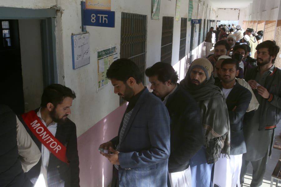 People stand in queue as they wait for their turn to cast vote outside a polling station during the country's parliamentary elections in Jamrud, in the Khyber district, Pakistan, Thursday, Feb. 8, 2024. Pakistanis lined braved cold winter weather and the threat of violence to vote for a new parliament Thursday, a day after twin bombings claimed at least 30 lives in the worst election-related violence ahead of the contested elections. (AP Photo/Muhammad Sajjad)