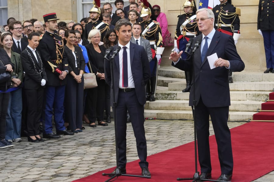 New French prime minister Michel Barnier, right, and outgoing prime minister Gabriel Attal deliver a speech during the handover ceremony, Thursday, Sept. 5, 2024 in Paris. President Emmanuel Macron has named EU's Brexit negotiator Michel Barnier as France's new prime minister after more than 50 days of caretaker government. (AP Photo/Michel Euler)