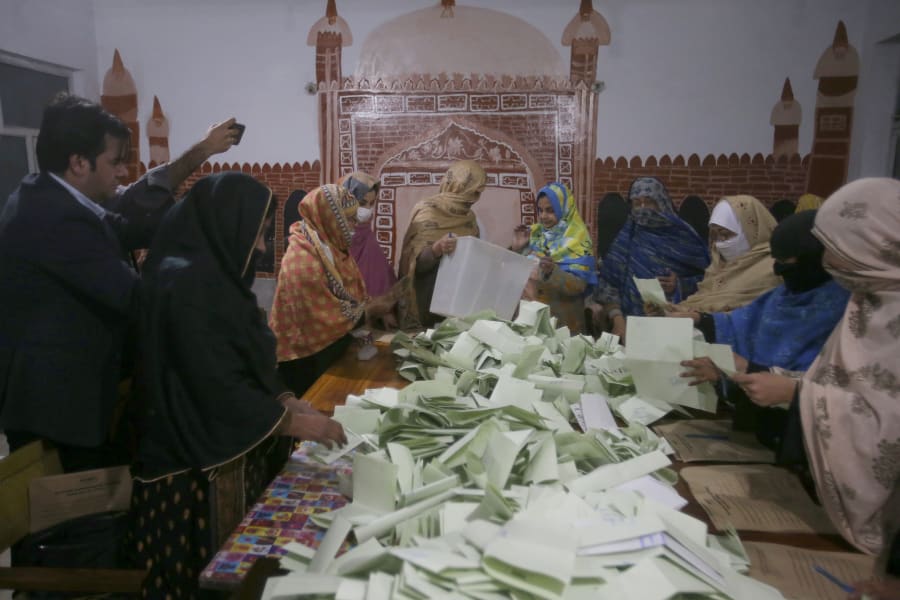 Members of polling staff count the votes after the polls closed for parliamentary elections, in Peshawar, Pakistan, Thursday, Feb. 8, 2024. (AP Photo/Muhammad Sajjad)