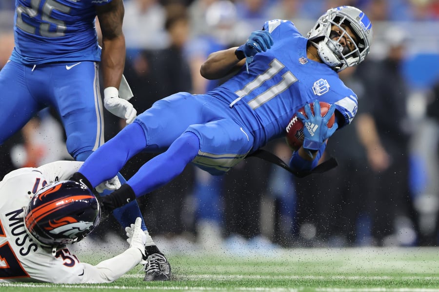 Kalif Raymond #11 of the Detroit Lions is tackled by Riley Moss #37 of the Denver Broncos during the first quarter at Ford Field on December 16, 2023 in Detroit, Michigan.