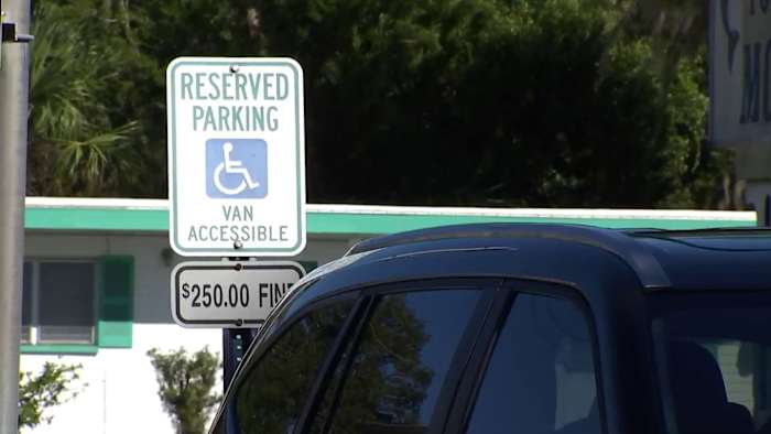 Reserved parking sign for accessible vans with a fine notice.