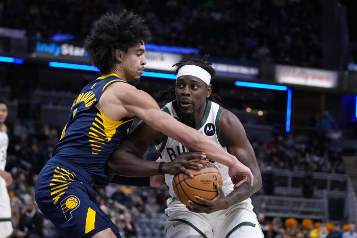 Los Angeles Clippers guard Paul George, left, dunks the ball against  Indiana Pacers guard Justin Holiday, back, during the first quarter of an  NBA basketball game, Sunday, Jan. 17, 2021, in Los