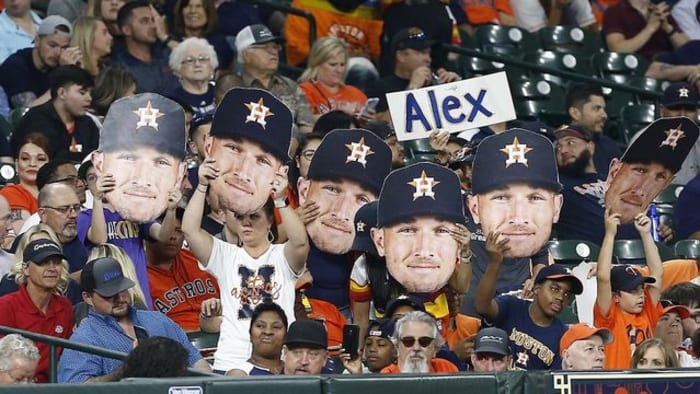 A fan holds a sign referencing the Houston Astros with an image of