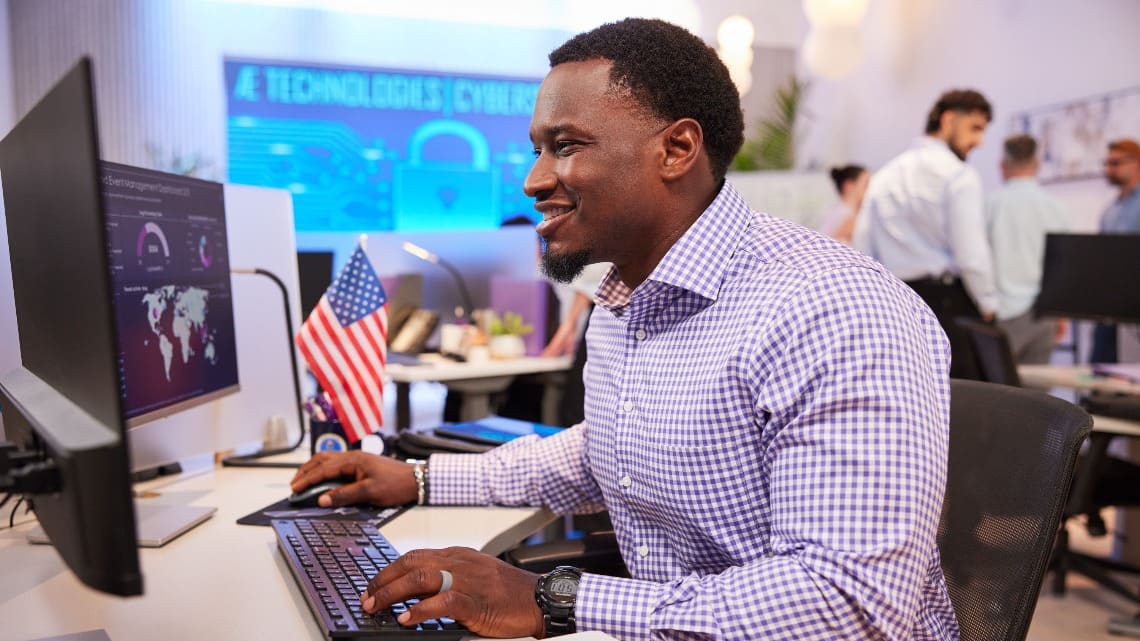 GCU cybersecurity student working at desk on computers