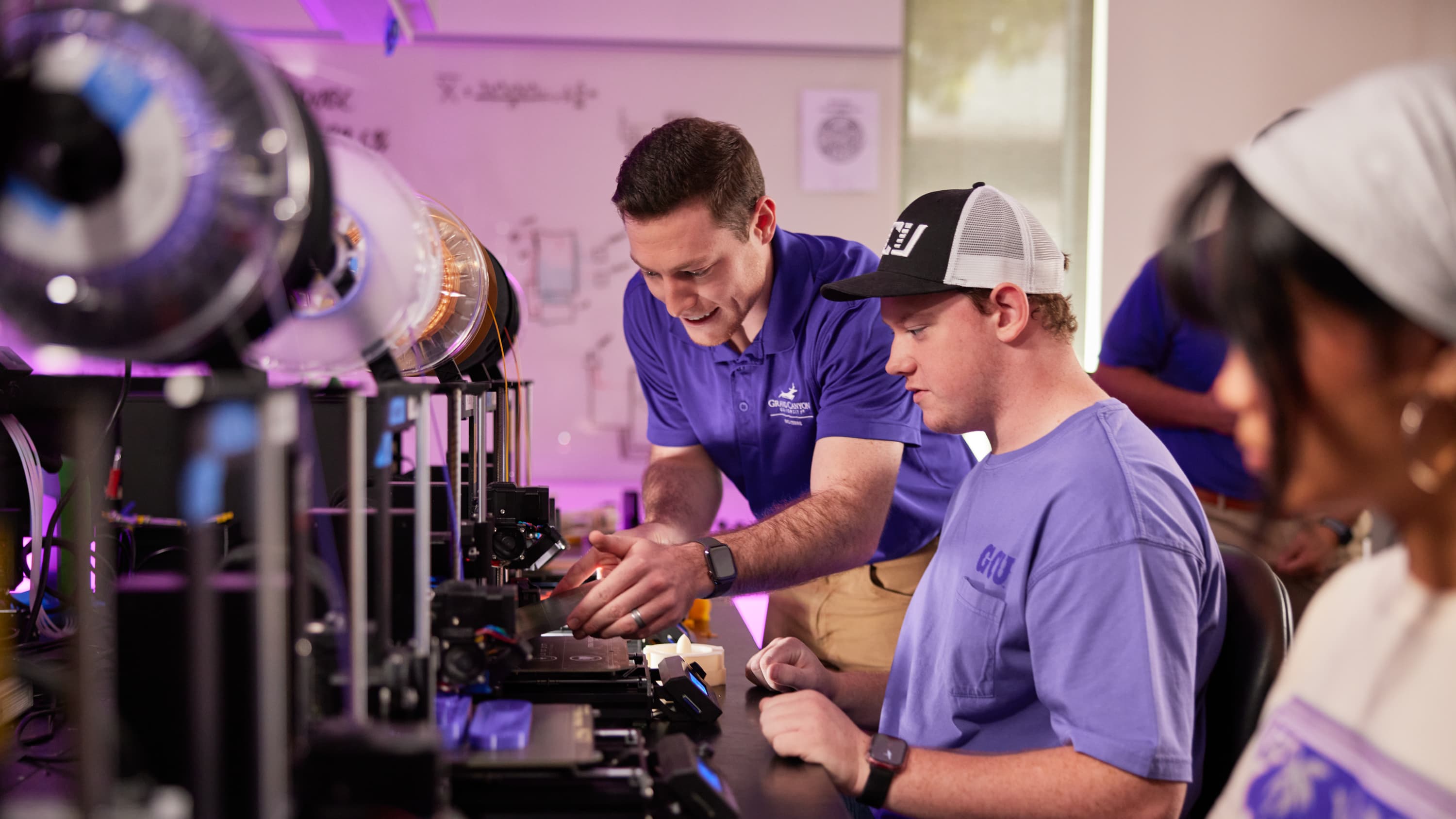 Students working with professor at computers