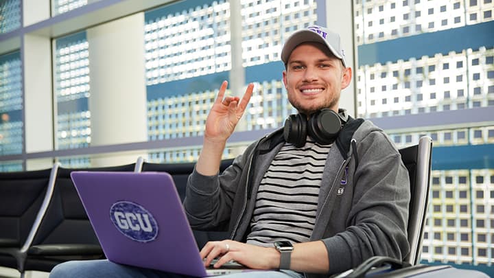 GCU Student on laptop sitting in chair
