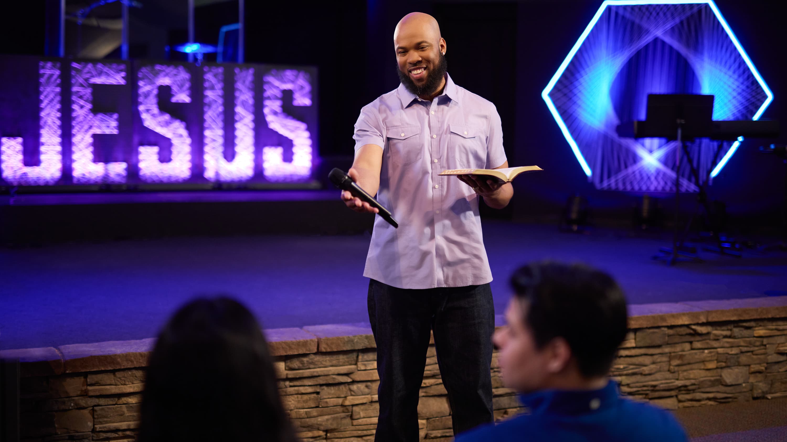 Male pastor speaking with people in congregation during a GCU chapel service