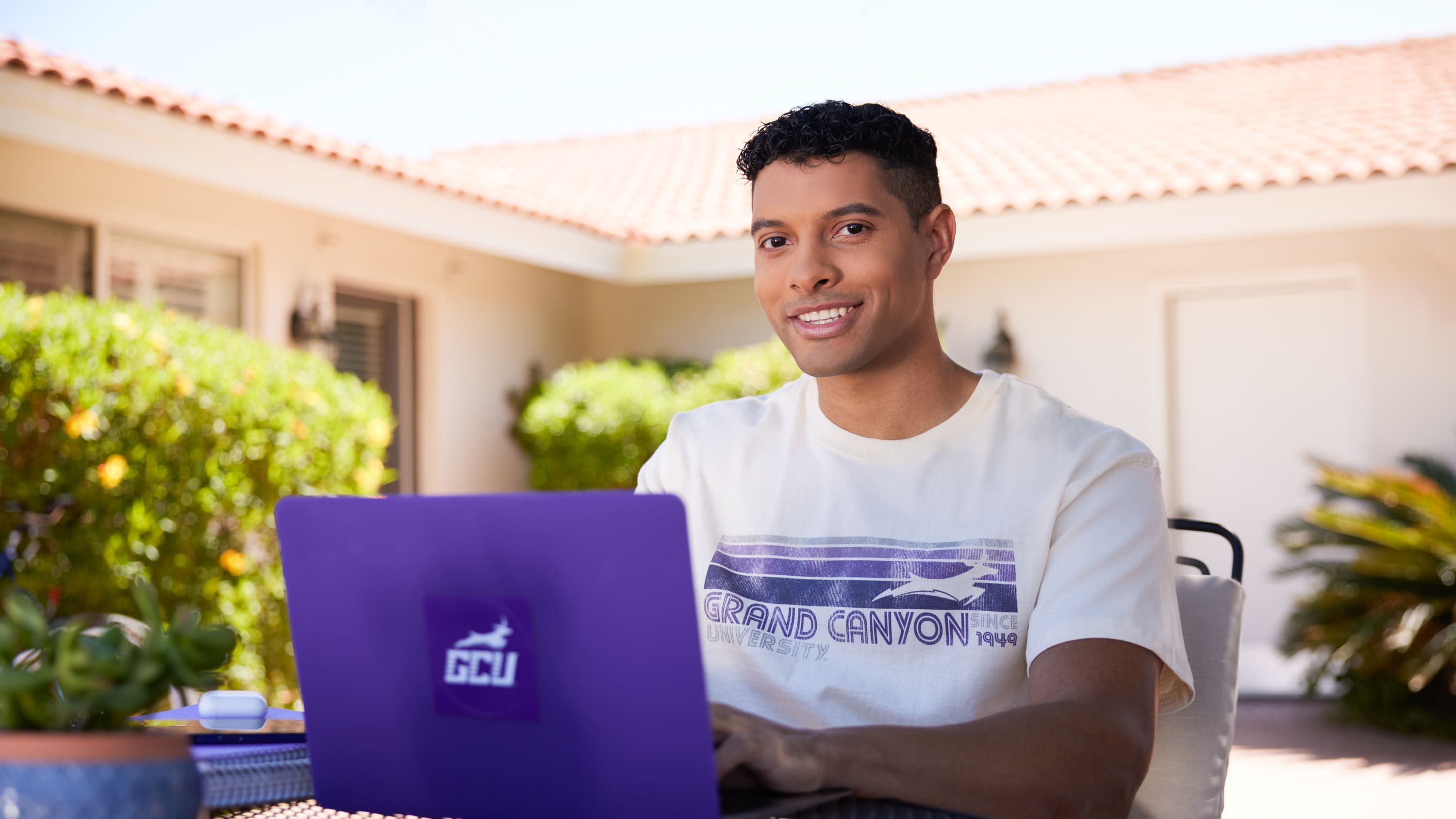 Male student smiling while working on computer