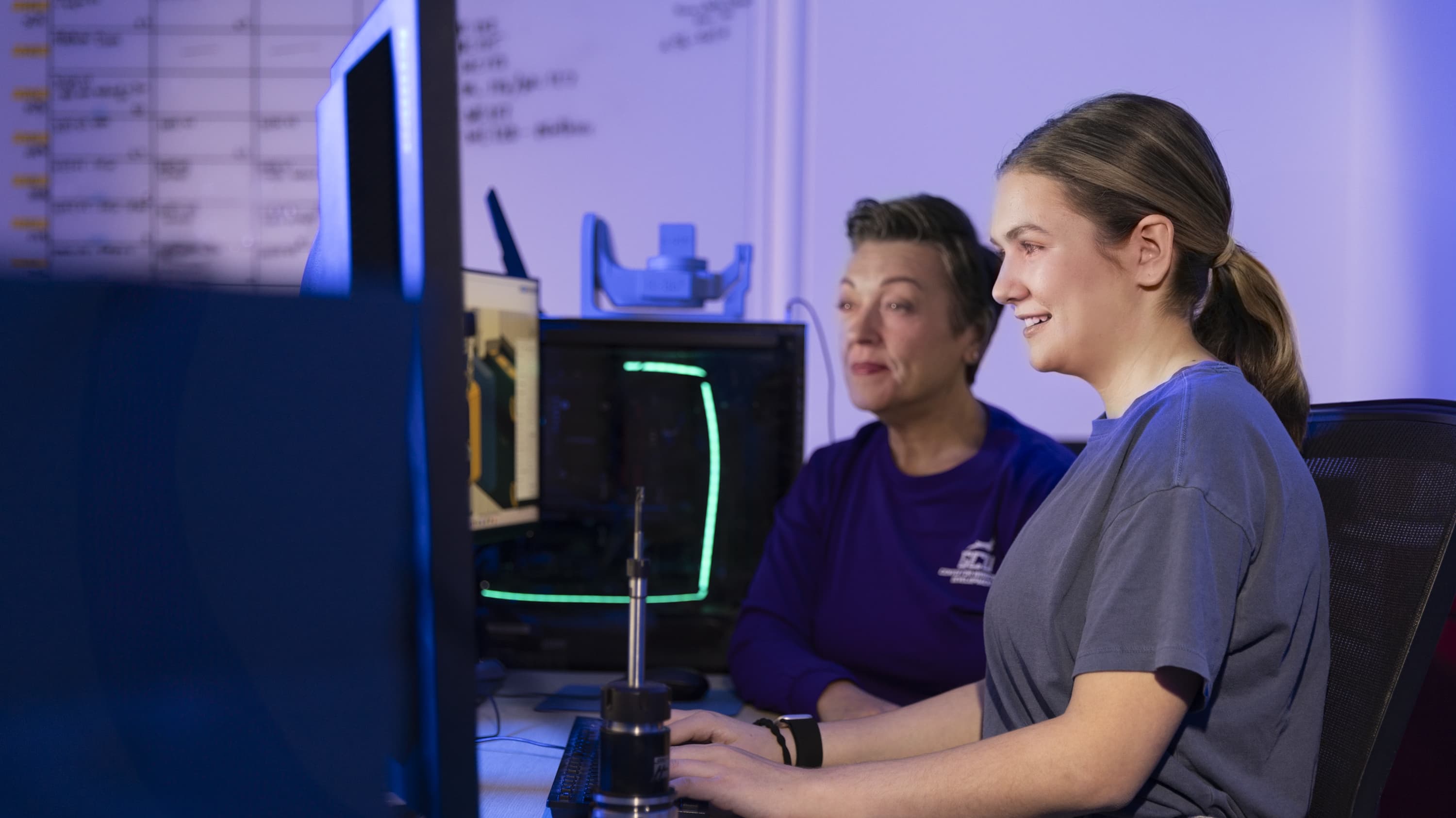 Female instructor working in computer lab with female software engineering major