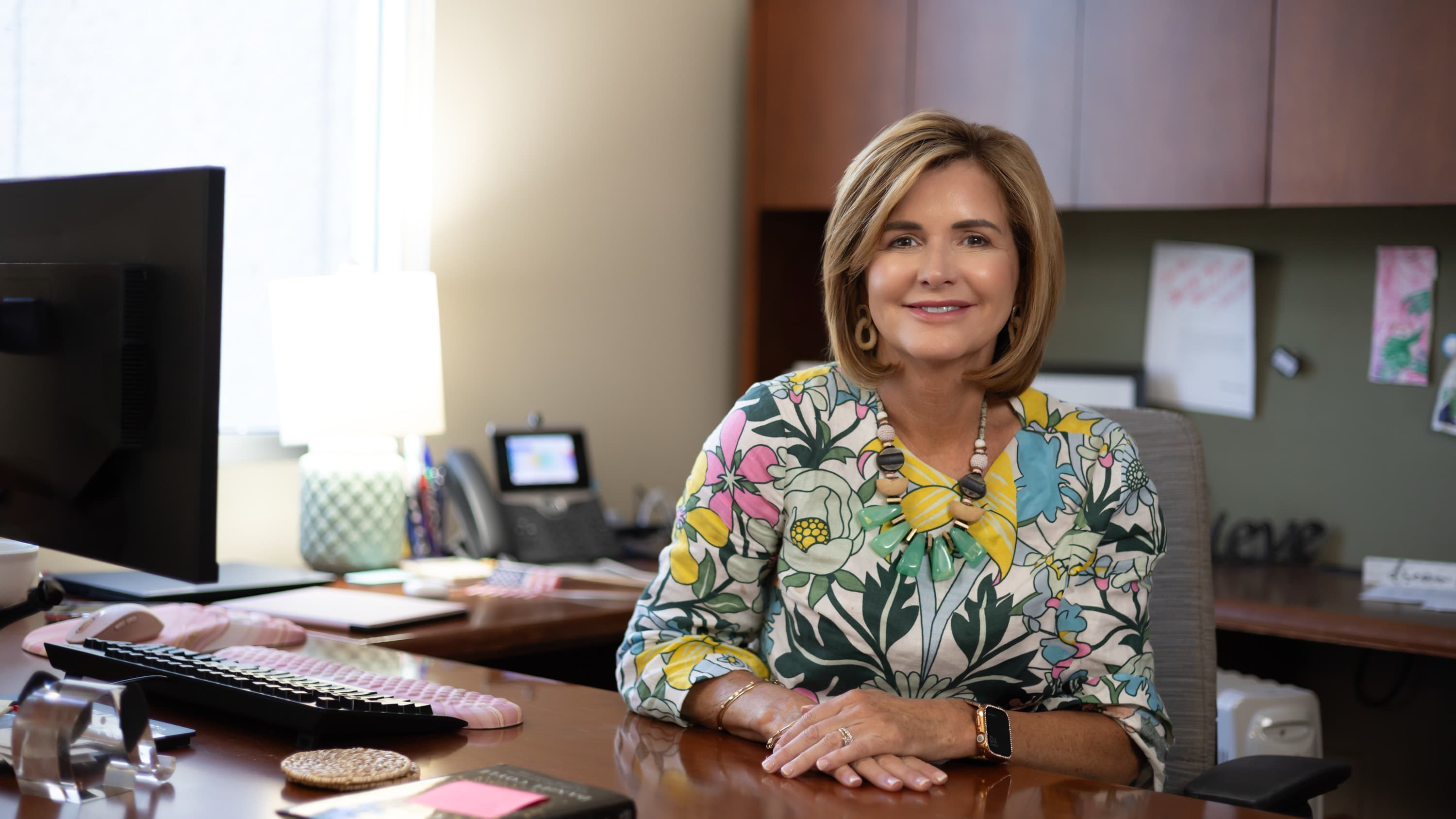 Female nursing administrator smiling at desk in office