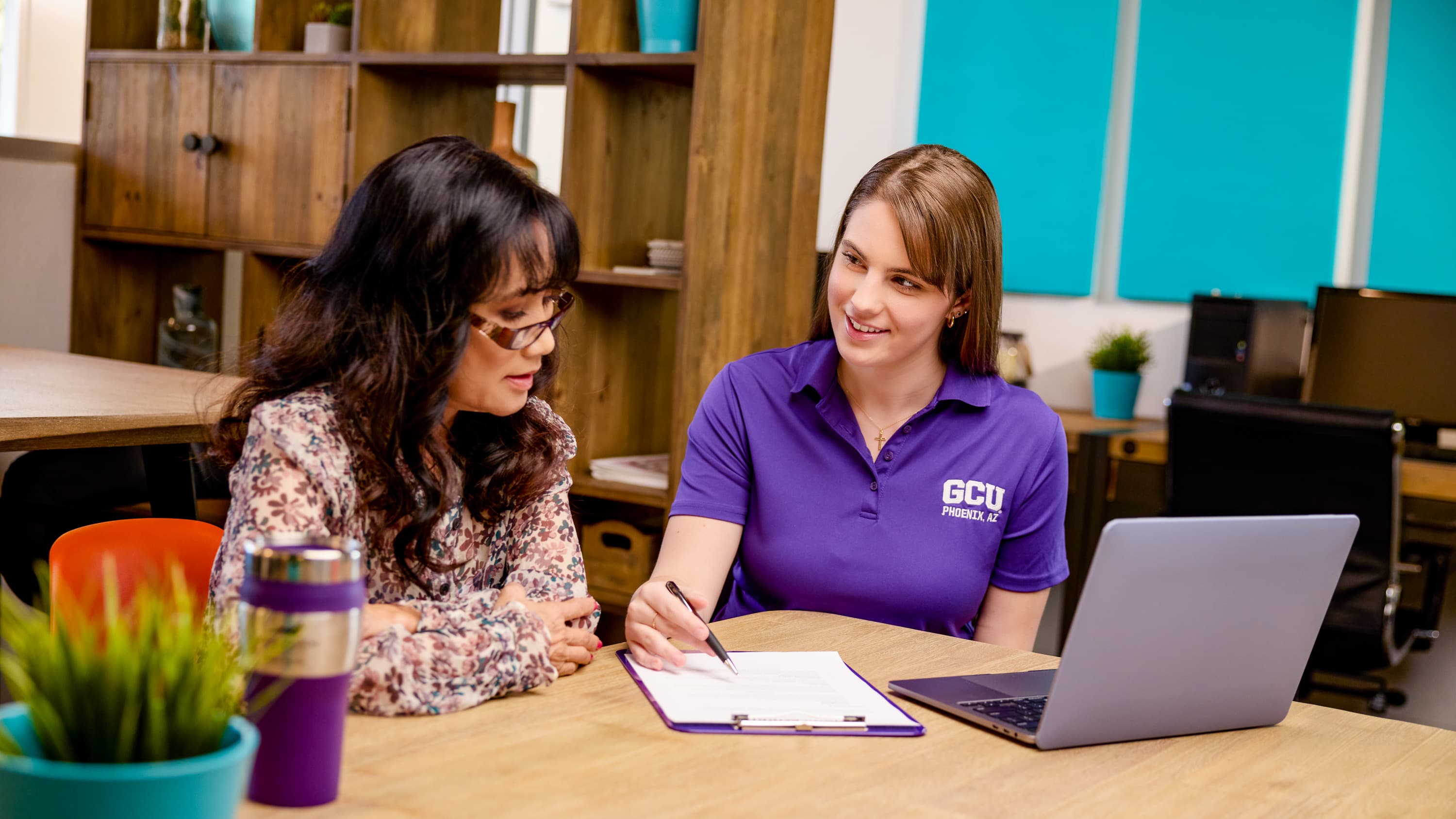 Female PhD degree student working with professor in classroom at GCU
