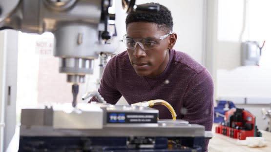 Male engineering degree student working with 3d printer in Lopes Live Lab at GCU
