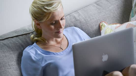Woman sitting on couch with laptop