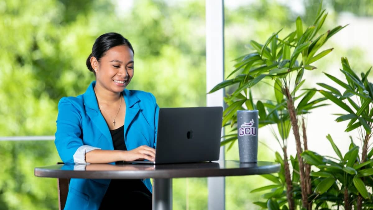 Business major at GCU using a laptop on campus