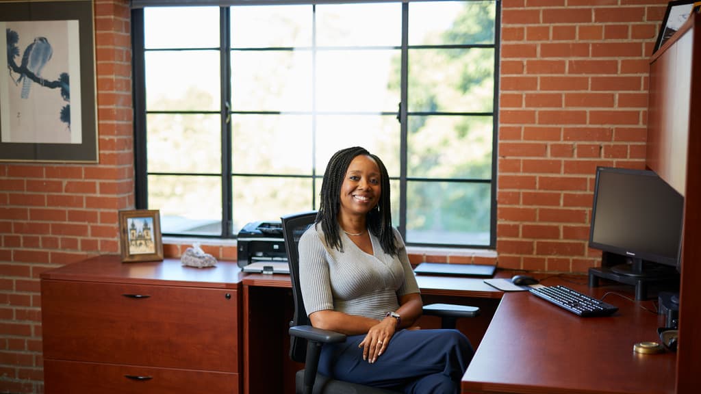 Doctoral Degree Holder Smiling At Her Desk