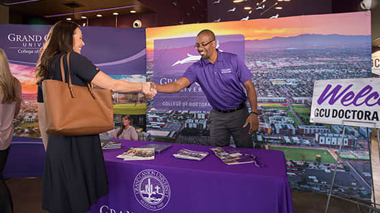 doctoral counselor with table at school fair