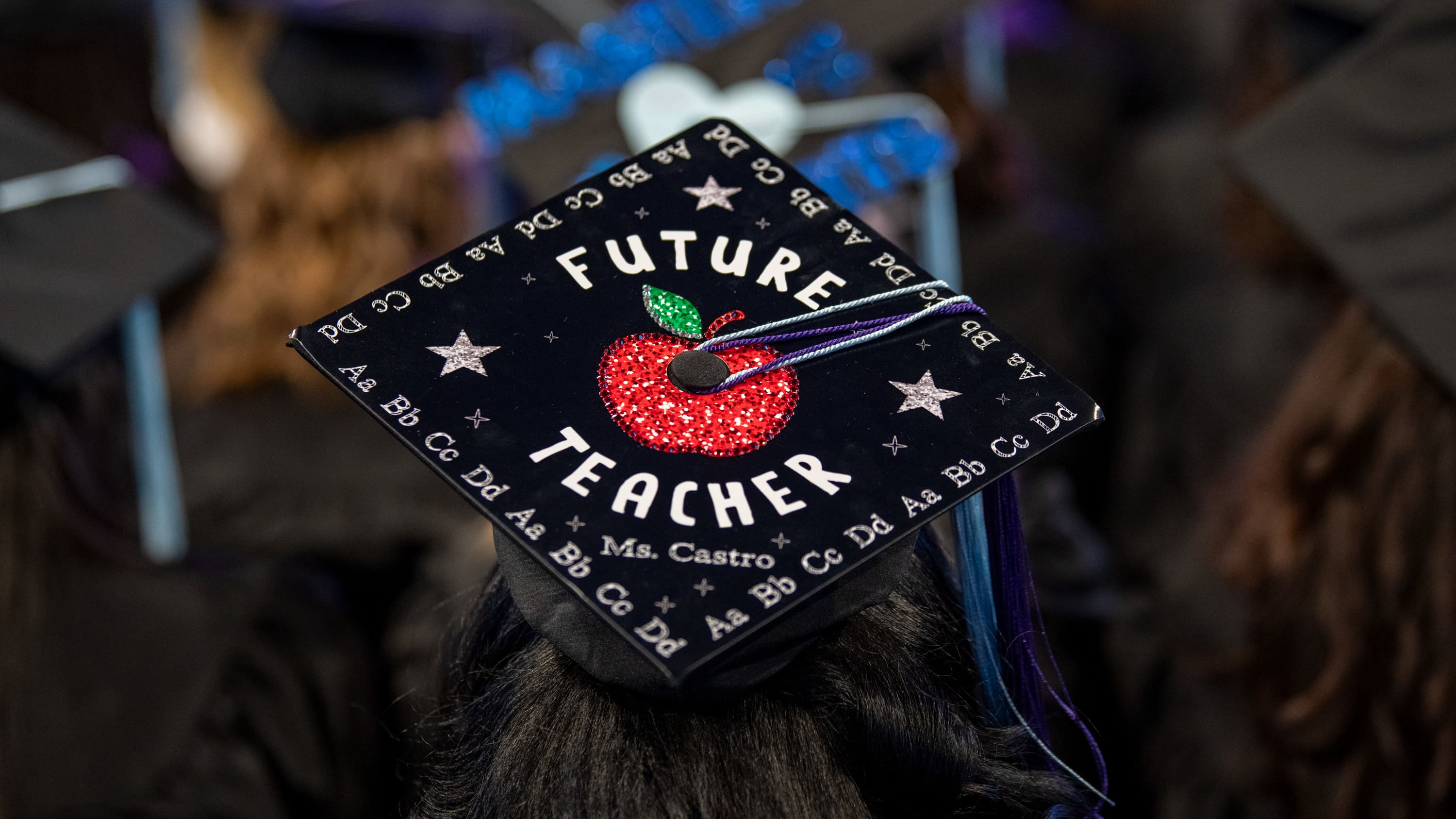 Education degree student at GCU's graduation ceremony wearing Future Teacher cap