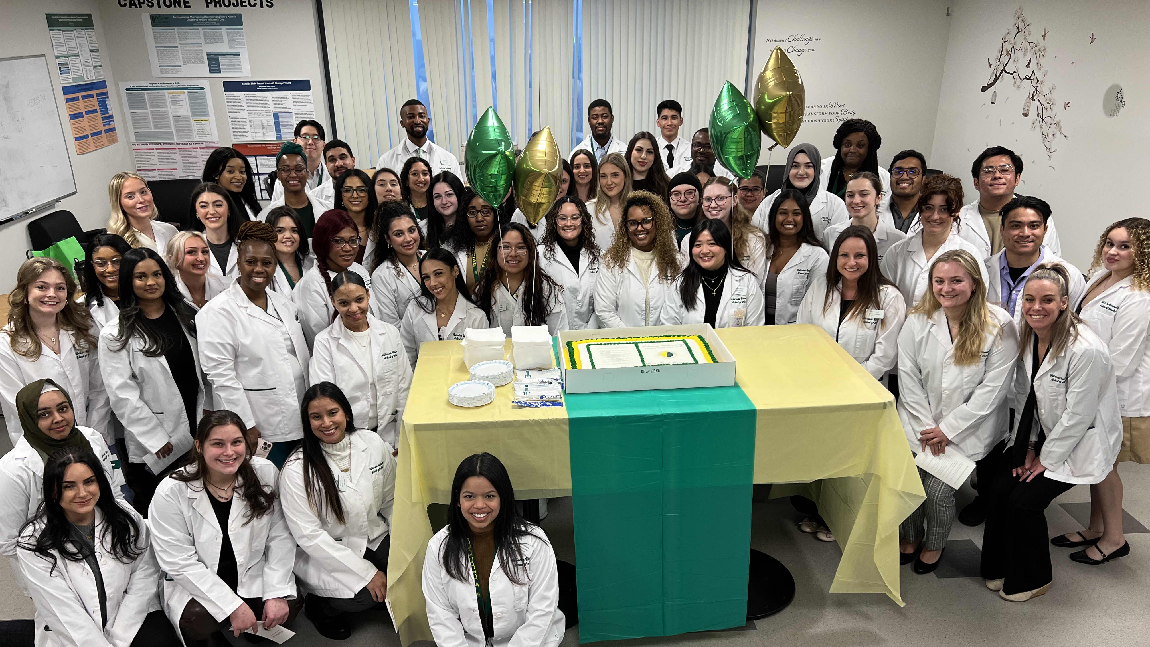 Group of DNP degree students smiling in white coats in GCU classroom for capstone presentation