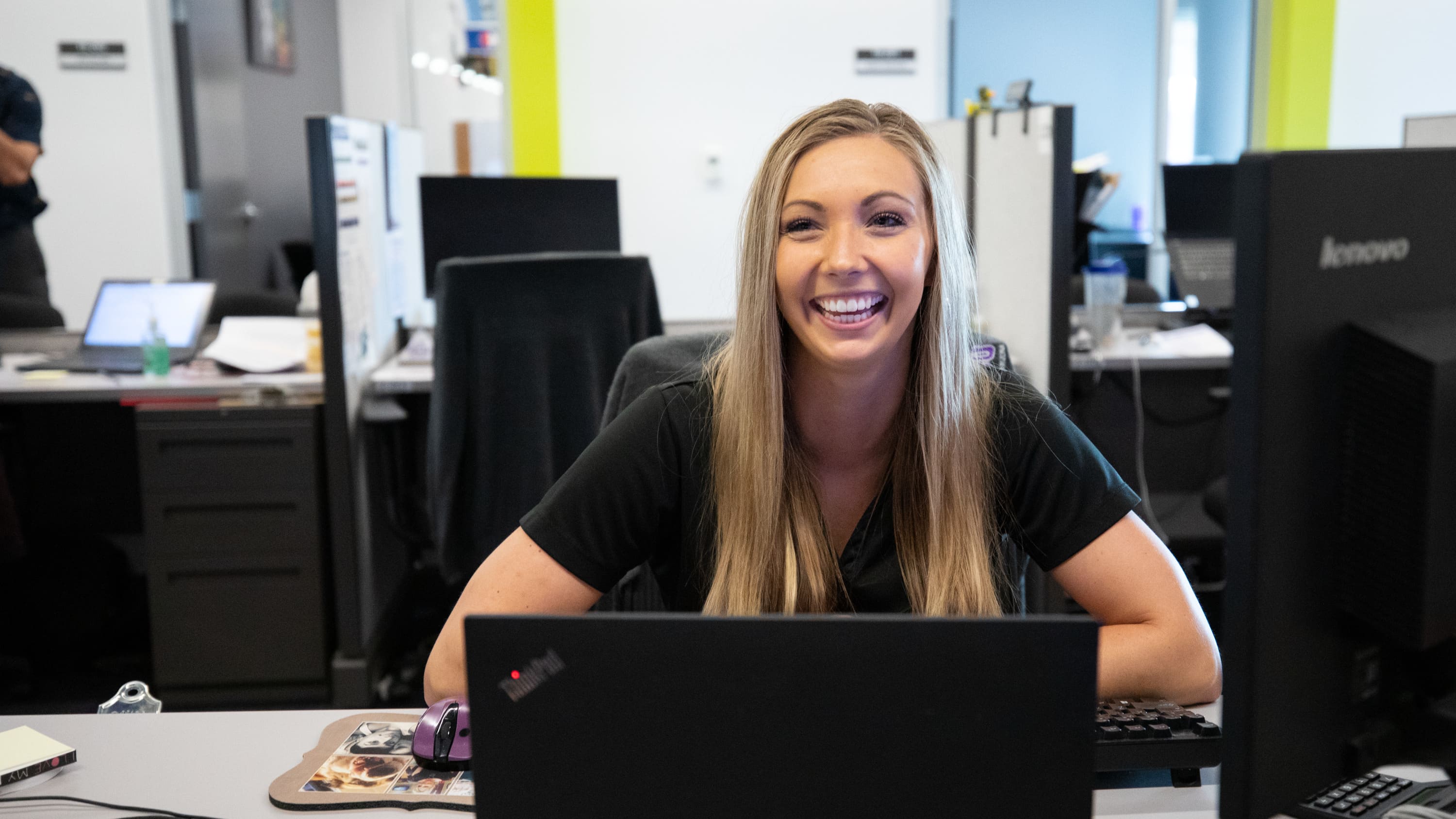 Blonde woman sitting at desk in front of a computer at Student Service Counselor
