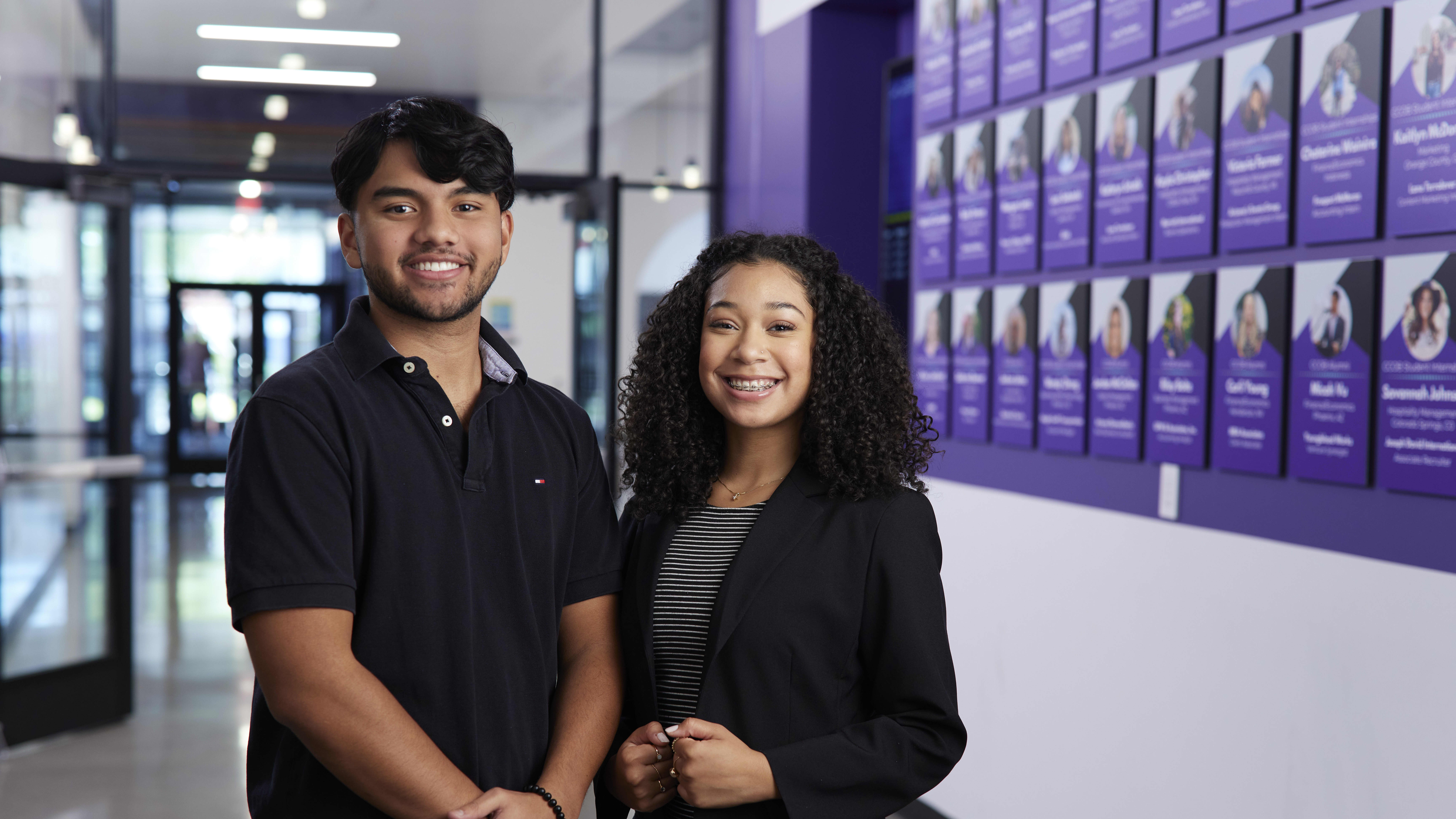 Male and female GCU students smiling in hallway on campus