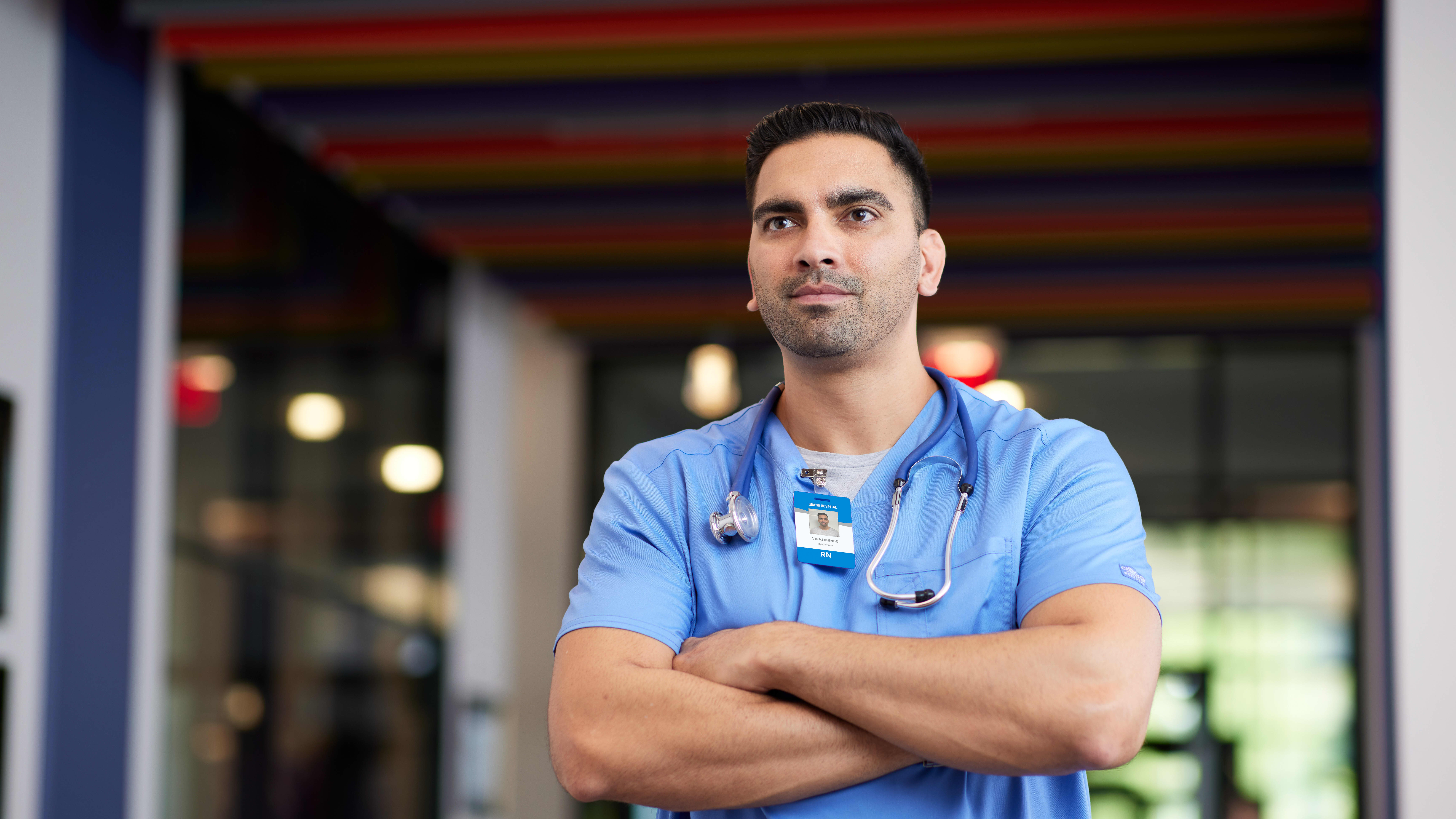Portrait of male healthcare certificate student posing in blue scrubs at GCU