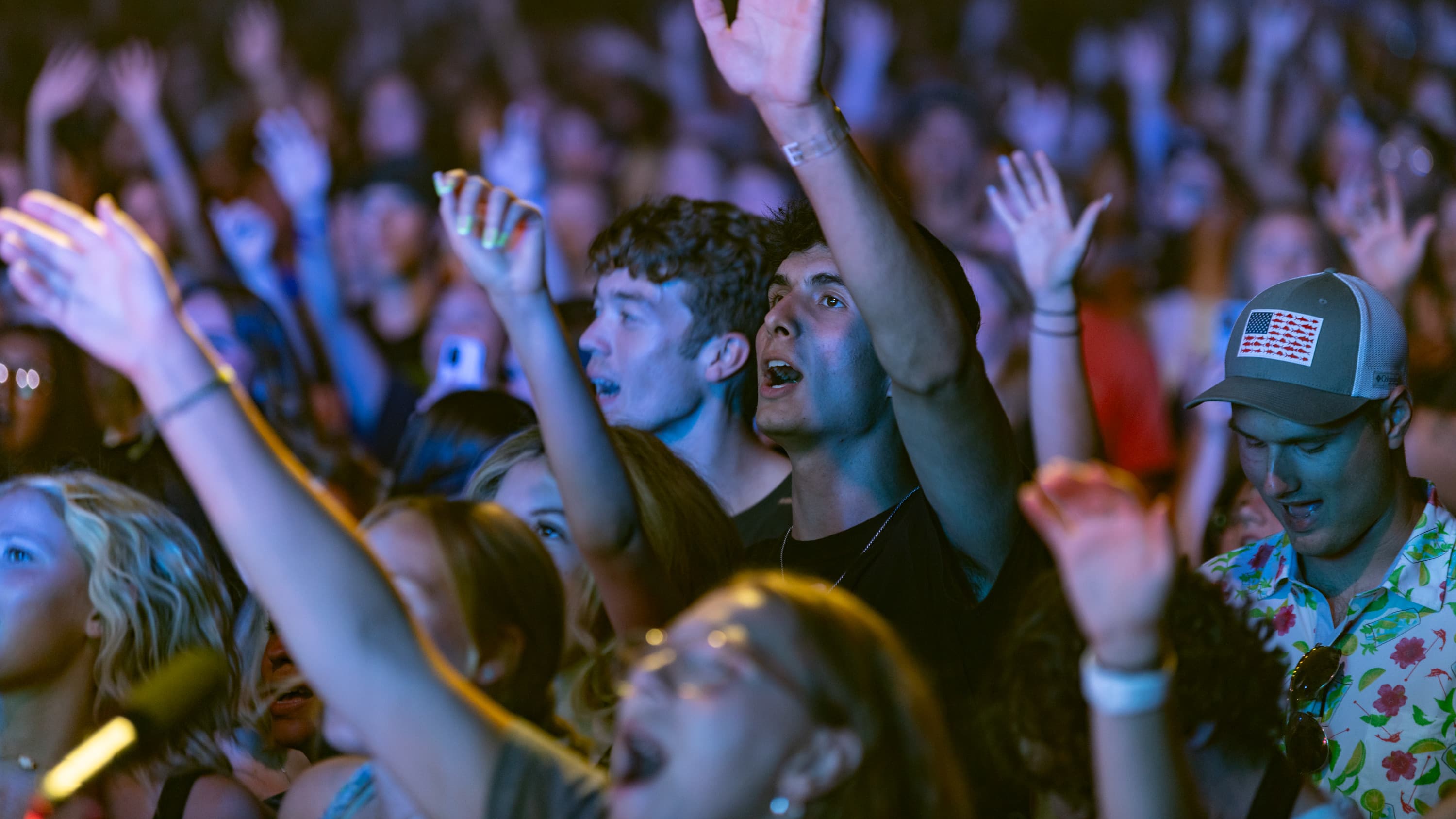 students at chapel with hands in the air