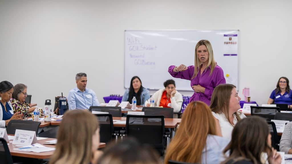 Woman standing in front of students teaching