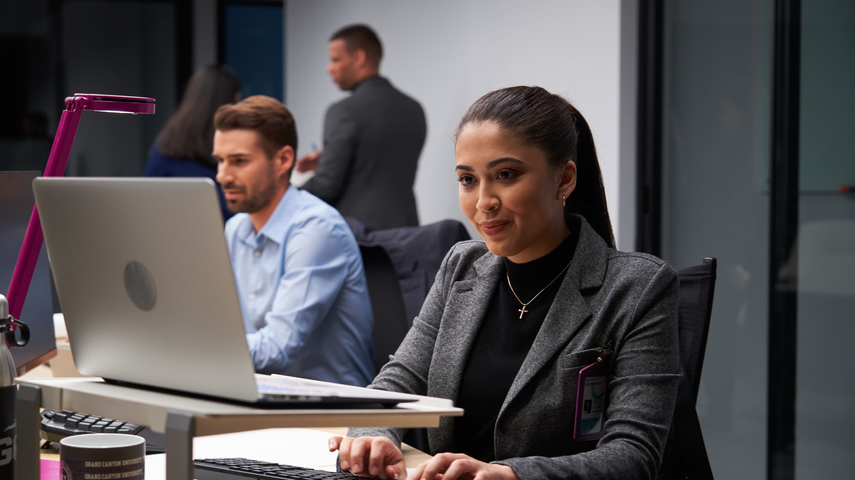 Male and female software engineers working on laptops in office