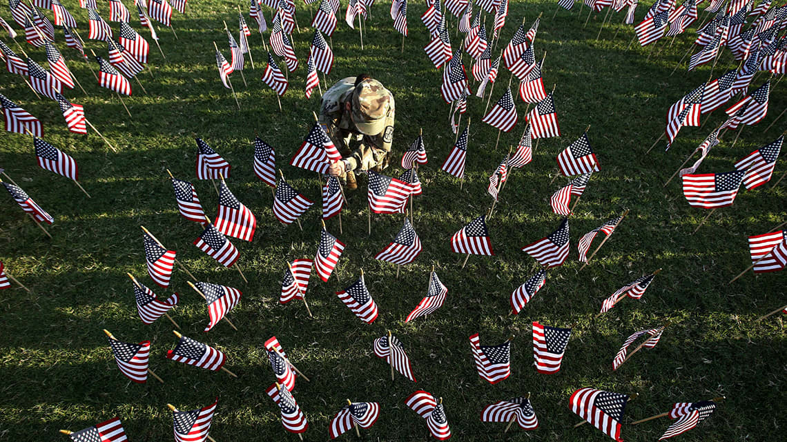 ROTC cadet puts out small American flags in honor of 9 11
