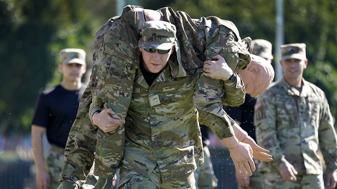 ROTC cadets in fatigues do exercise science trainings carrying people to simulate rescue operations