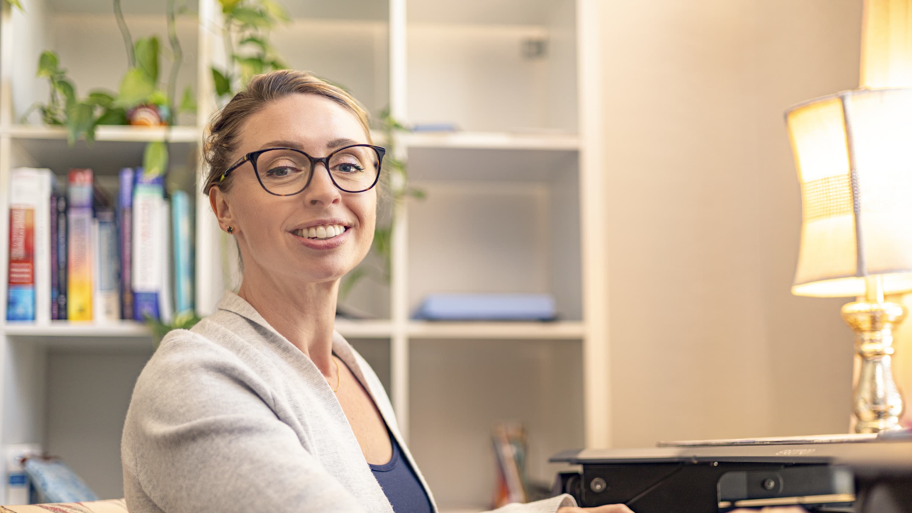 Woman sitting in home office looking at GCU doctoral admission requirements online