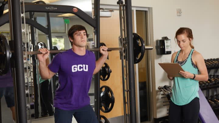 Male and female healthcare degree students exercising in gym at GCU