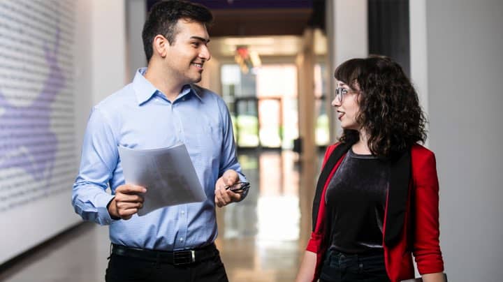 Business and management students talk in a hallway at GCU