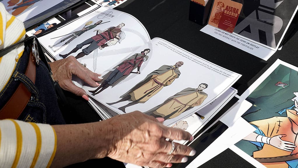 Female viewing students animation portfolio at the Design Showcase