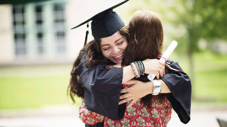 GCU Graduate Smiles and Hugs Loved One