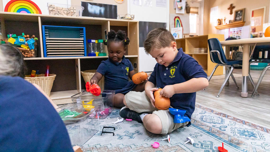 Children playing with toys on the ground in a classroom setting
