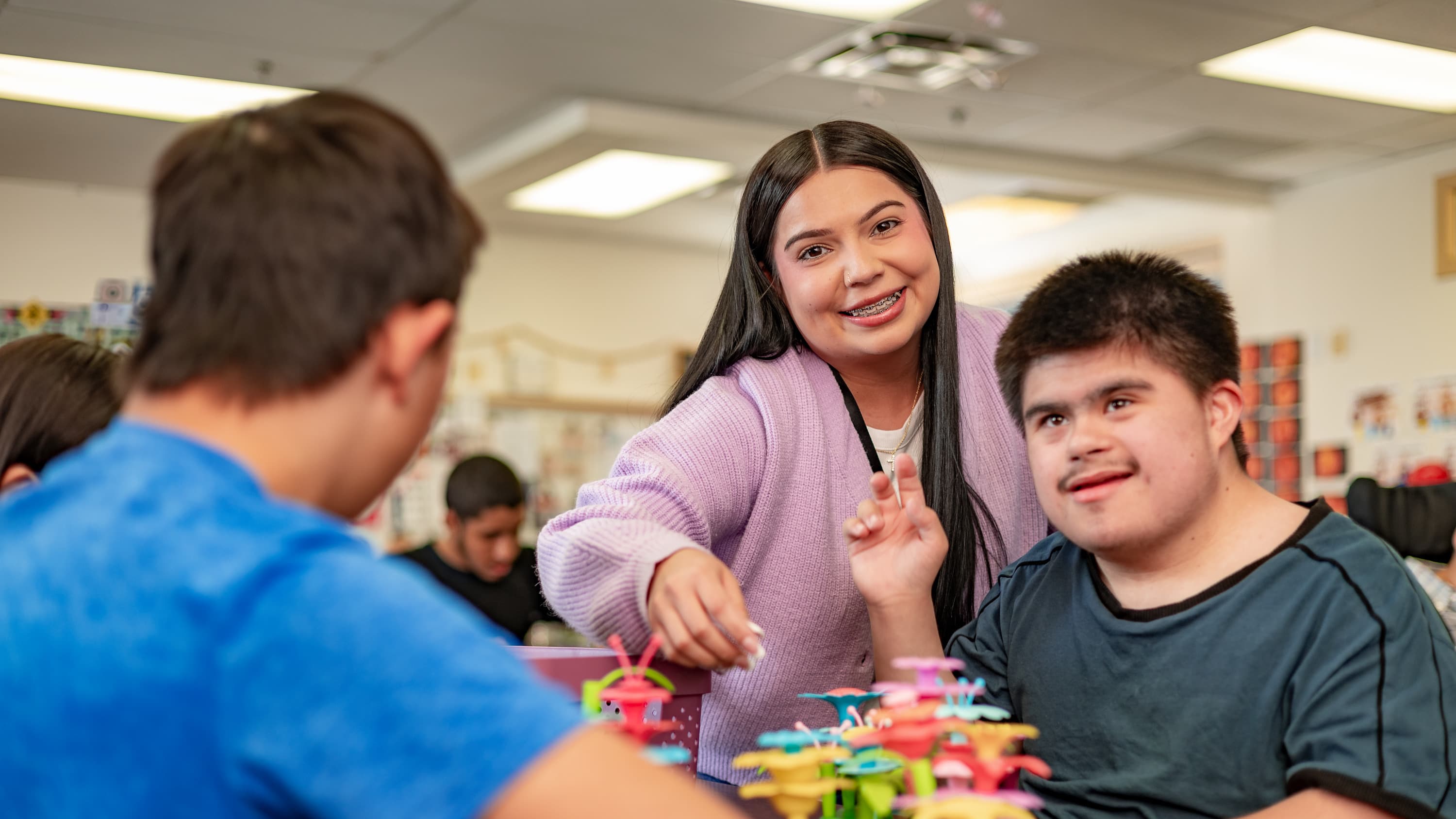 Educator working with special needs student in a classroom setting