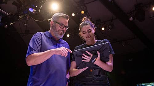 Bill Symington works through theatre production design with student on an ipad