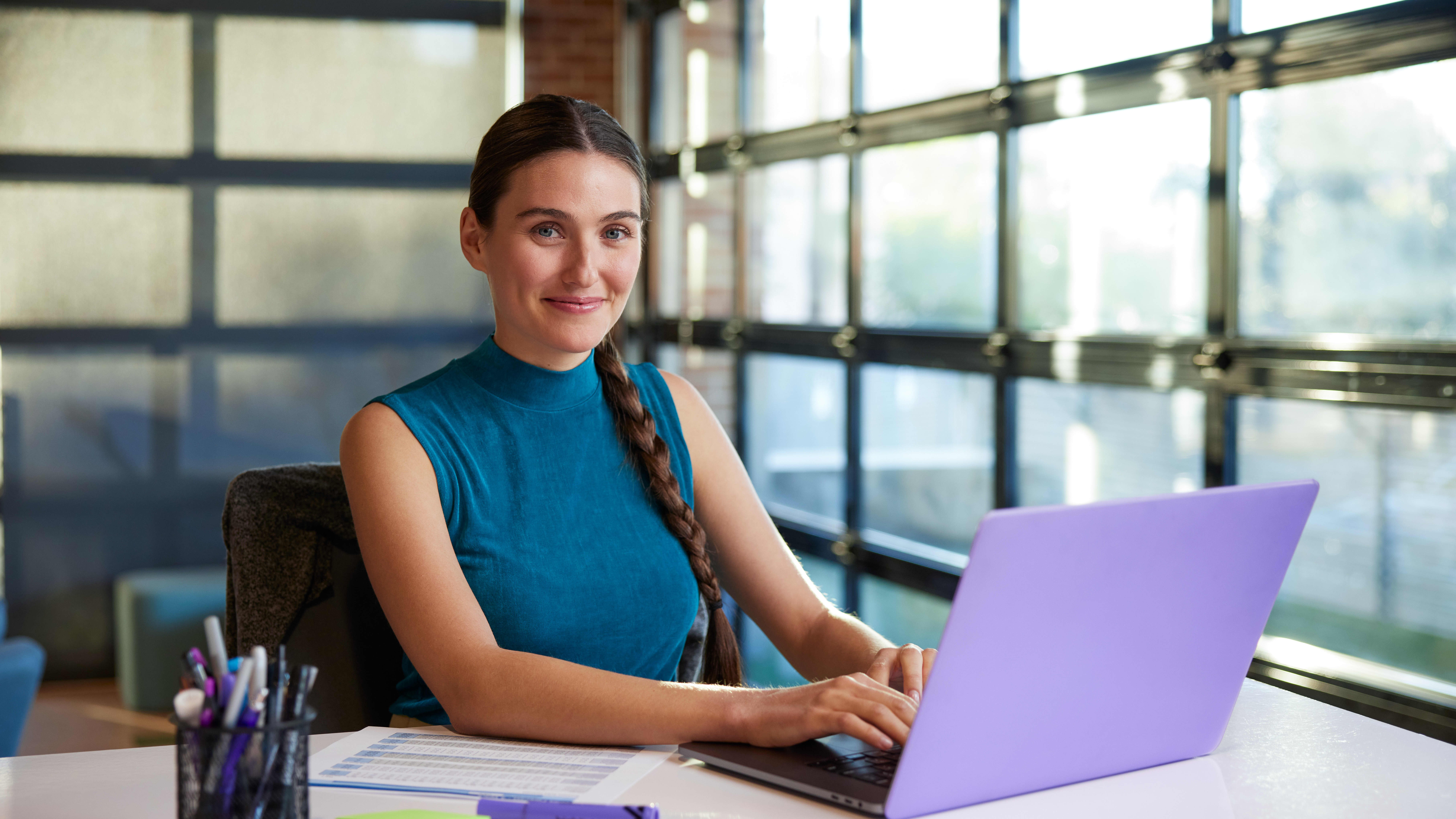 Online accounting student sitting at a desk and typing on laptop