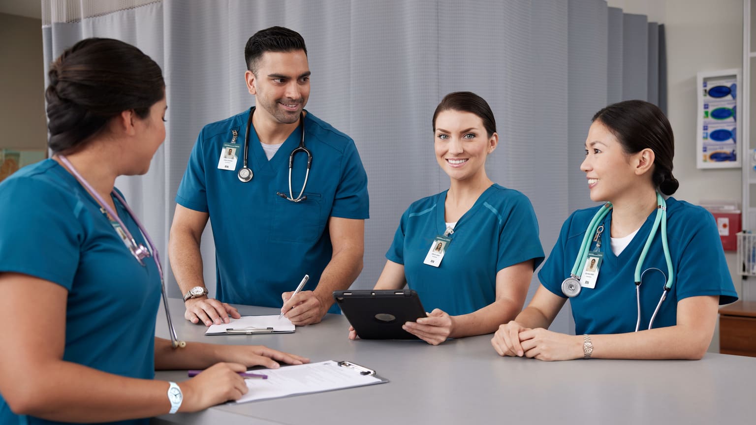 Male and female public health employees reviewing patient records in hospital