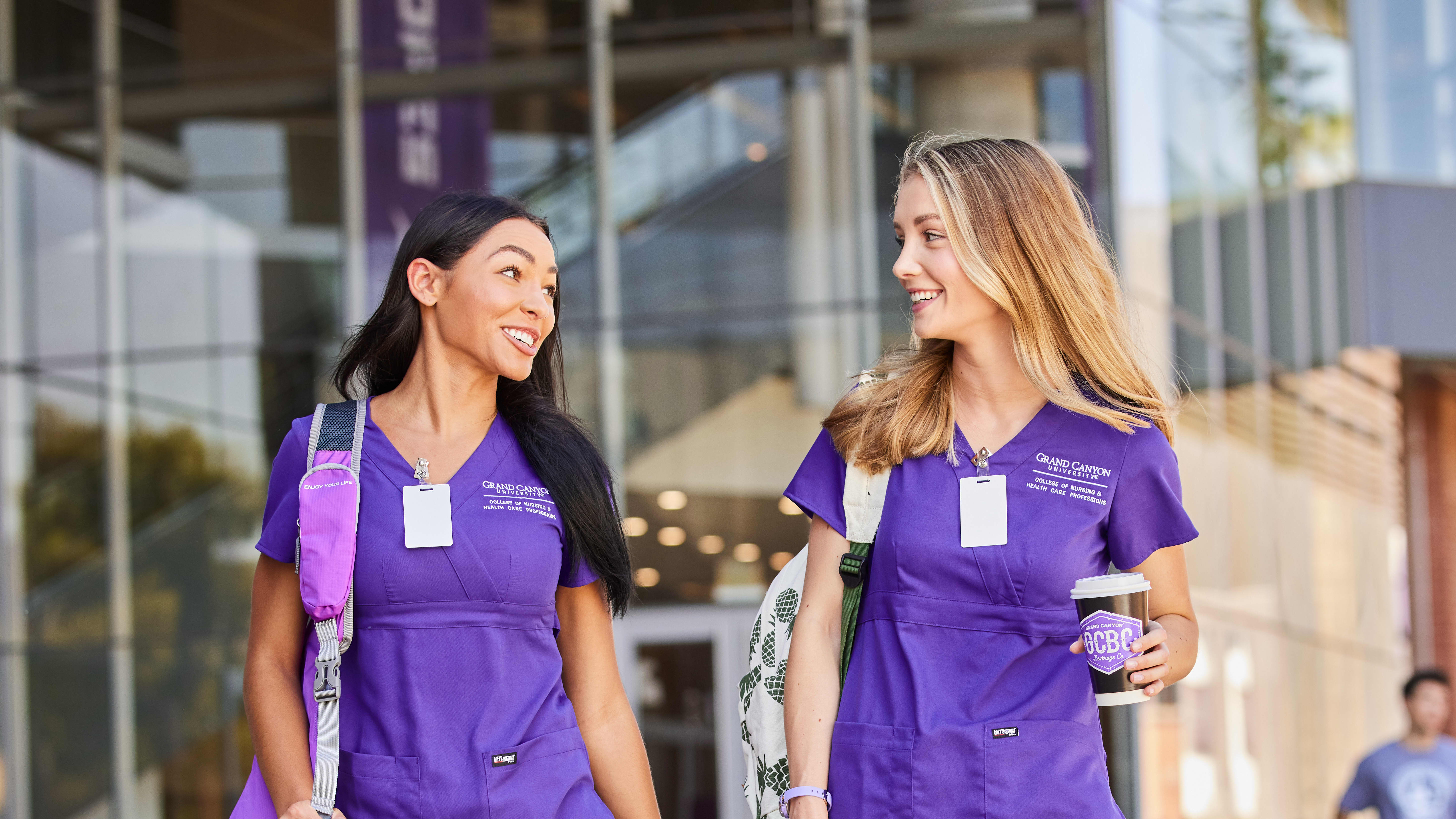 Group of New Mexico ABSN students in purple scrubs talking with each other outside