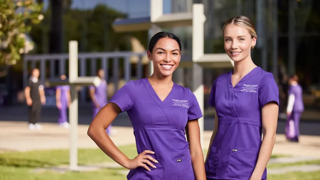 Two female nursing students in purple scrubs