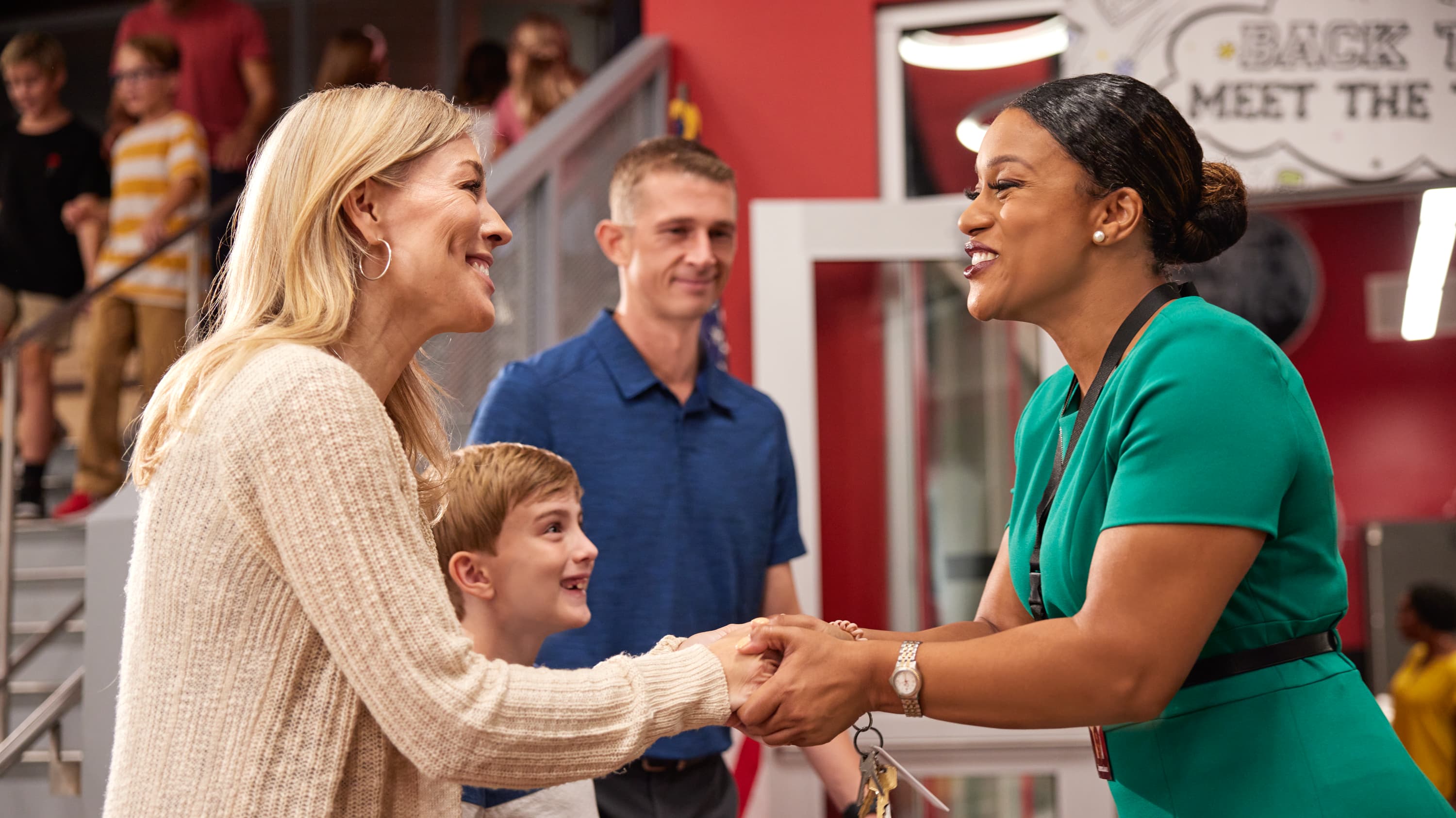 Teacher shaking hands with parents on meet the teacher night