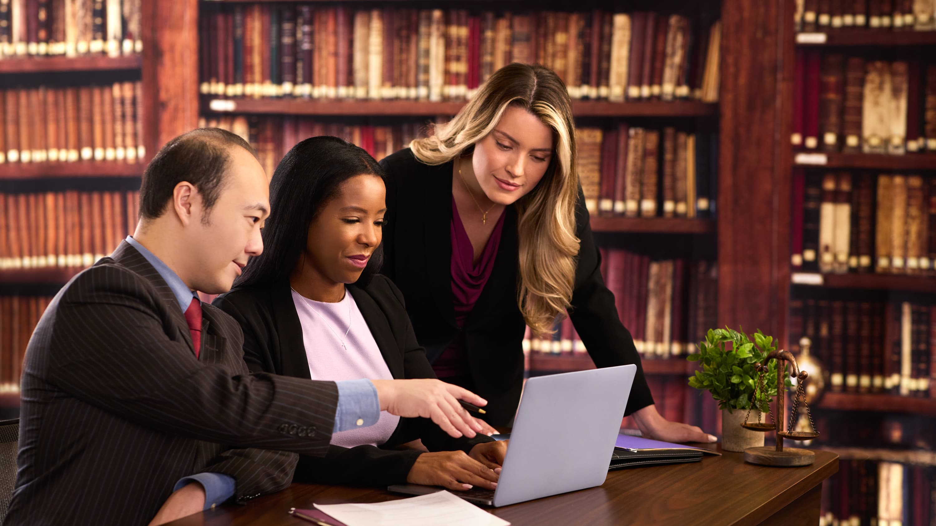 Psychologists in library conducting research on laptop