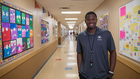 teacher standing in hallway smiling at camera