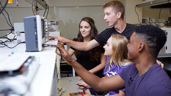 Engineering students working on electronic device