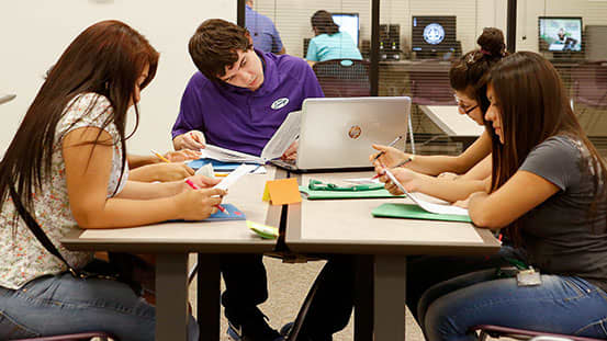 Four GCU learning lounge students sitting at square table 